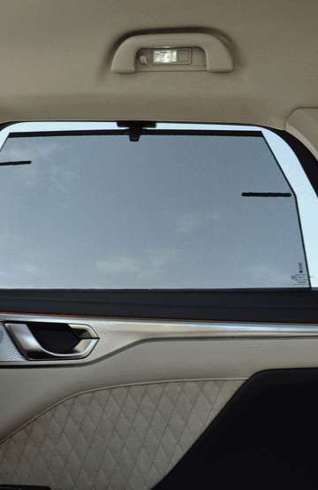 a second-row car window with sun shades in a wey coffee 01 car