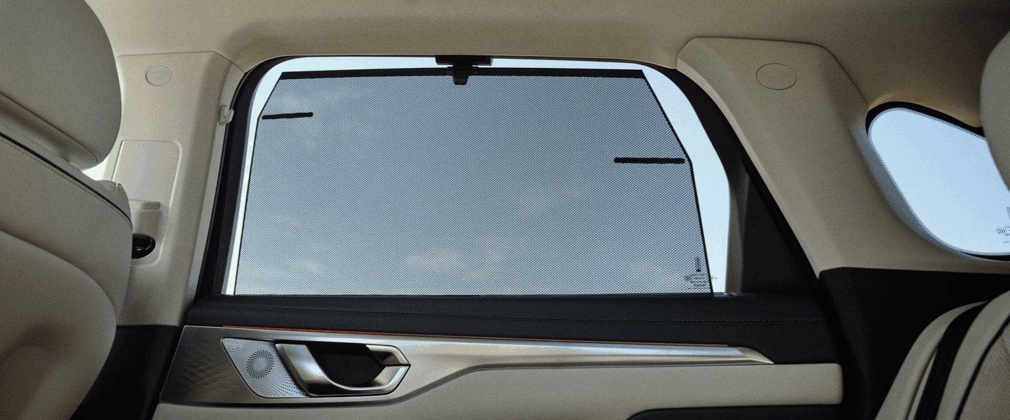 a second-row car window with sun shades in a wey coffee 01 car