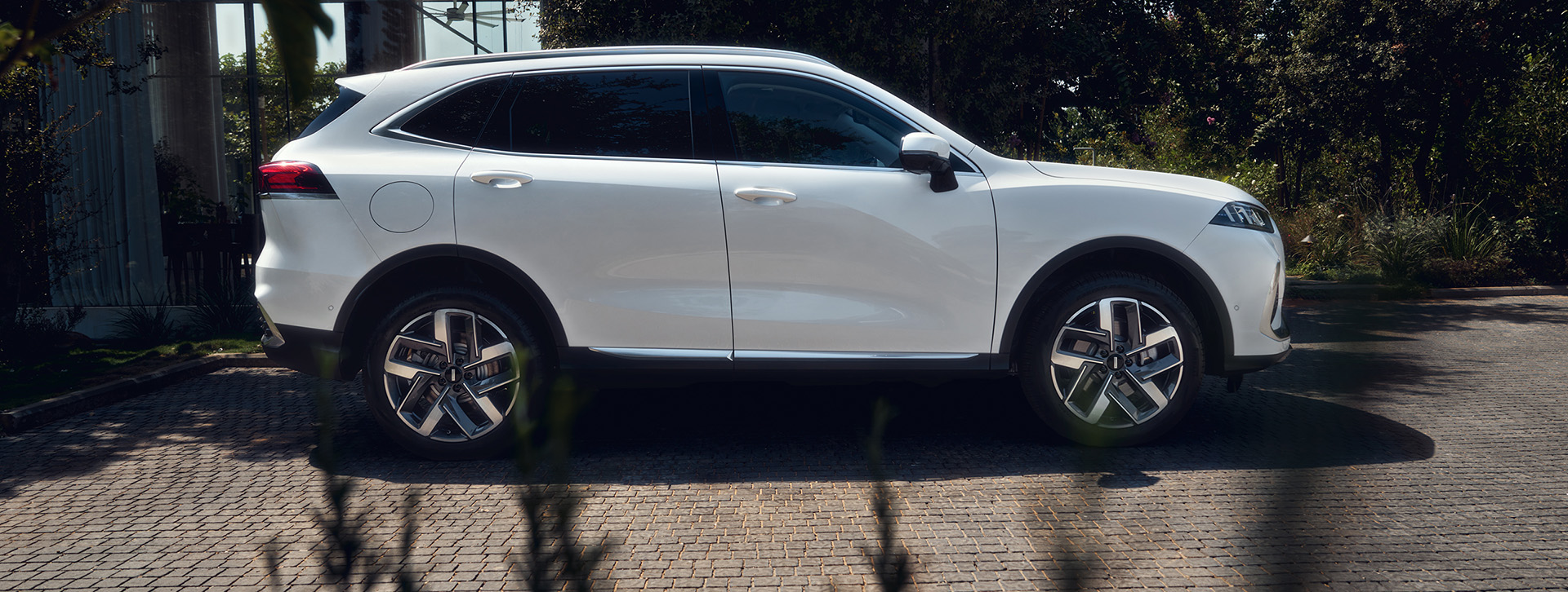 a white wey coffee 01 car is standing outside facing the sea